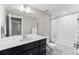 Clean bathroom with a white tub and dark vanity at 5524 Uinta St, Denver, CO 80238