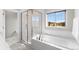 Elegant bathroom with soaking tub, shower, and white tile at 5524 Uinta St, Denver, CO 80238