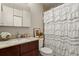 Classic bathroom with a wood cabinet vanity and a white ruffled shower curtain at 8555 Fairmount Dr # G208, Denver, CO 80247