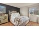 Bright bedroom featuring a large window, modern accent wall, and comfortable bed at 8555 Fairmount Dr # G208, Denver, CO 80247