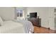 Cozy bedroom featuring a modern dresser, sleek TV, light-colored curtains, and wood floors at 8555 Fairmount Dr # G208, Denver, CO 80247