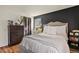 Bedroom featuring a dark accent wall, bright window, stylish furniture, and wood flooring at 8555 Fairmount Dr # G208, Denver, CO 80247
