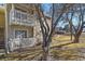 Multi-level condo building with charming balconies surrounded by mature trees and a grassy area at 8555 Fairmount Dr # G208, Denver, CO 80247