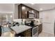 Modern kitchen featuring dark wood cabinets, stainless steel appliances, and granite countertops at 8555 Fairmount Dr # G208, Denver, CO 80247
