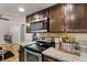 Cozy kitchen featuring stainless steel appliances, custom wood cabinets, and stylish countertops at 8555 Fairmount Dr # G208, Denver, CO 80247