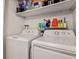 Convenient laundry area with white appliances and shelving for organized storage at 8555 Fairmount Dr # G208, Denver, CO 80247