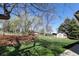 Picturesque backyard with lush lawn, mature trees, rock borders, and storage building at 2539 Lake Meadow Dr, Lafayette, CO 80026