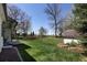 Expansive backyard featuring lush green grass, mature trees, storage shed, and landscaping at 2539 Lake Meadow Dr, Lafayette, CO 80026
