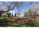 Serene backyard with green lawn, garden beds, mature trees, and partial wooden fence at 2539 Lake Meadow Dr, Lafayette, CO 80026
