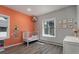 Charming Bedroom features light gray walls, a coral accent wall, and a cute crib near a bright window at 2539 Lake Meadow Dr, Lafayette, CO 80026