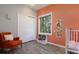 Serene Bedroom showcasing a cozy chair, stylish wood floors, a crib, and bright coral-colored wall at 2539 Lake Meadow Dr, Lafayette, CO 80026