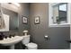Elegant half bath with a pedestal sink, framed artwork, and soft lighting, providing a stylish space at 2539 Lake Meadow Dr, Lafayette, CO 80026