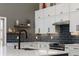 Tastefully updated kitchen with white cabinets, a black backsplash, and stainless steel appliances at 2539 Lake Meadow Dr, Lafayette, CO 80026