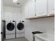 Functional laundry room with modern washer and dryer, ample storage cabinets, and utility sink at 2539 Lake Meadow Dr, Lafayette, CO 80026