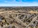 An aerial view of a neighborhood showcasing the community layout, nearby open spaces, and distant city skyline at 7359 S Monaco St, Centennial, CO 80112