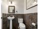 Chic powder room features a pedestal sink and dark tiled walls at 902 Jarvis Dr, Erie, CO 80516