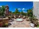 Backyard patio with fire pit, surrounded by chairs and decorative brickwork with lush greenery at 902 Jarvis Dr, Erie, CO 80516