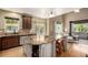 Bright kitchen with island seating, hardwood floors, and access to the living room at 902 Jarvis Dr, Erie, CO 80516