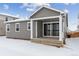 Gray house exterior with covered patio and snowy yard at 4519 Boone Cir, Brighton, CO 80601