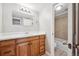 Bathroom features a wood vanity, a shower and tub combination, and neutral tile flooring at 6490 S Dayton St # L02, Englewood, CO 80111
