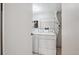 White washer and dryer set in an organized laundry room area with overhead shelving at 6490 S Dayton St # L02, Englewood, CO 80111