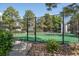 Community tennis court enclosed by a black fence, surrounded by mature trees at 6490 S Dayton St # L02, Englewood, CO 80111