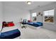 Simple bedroom features twin beds, carpeted floor and bright natural light through two windows at 857 Gold Hill Dr, Erie, CO 80516