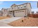 Well-manicured front yard highlighting the home's curb appeal and showcasing a two-car garage at 857 Gold Hill Dr, Erie, CO 80516