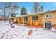 Spacious backyard featuring a covered patio, Adirondack chairs, grill, and a snowy landscape at 12286 W Tennessee Ave, Lakewood, CO 80228