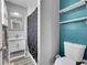 Well-lit bathroom with a modern vanity, mirror, toilet and white shower with dark patterned curtain at 12286 W Tennessee Ave, Lakewood, CO 80228