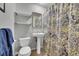 Functional bathroom featuring a pedestal sink, toilet, and a shower with patterned curtain at 12286 W Tennessee Ave, Lakewood, CO 80228