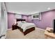 Bedroom with purple walls, carpeted floor, dark furniture, and natural light from two windows at 12286 W Tennessee Ave, Lakewood, CO 80228