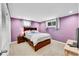 Cozy bedroom with neutral carpet, complemented by a dark wood bed frame and lavender painted walls at 12286 W Tennessee Ave, Lakewood, CO 80228