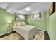 Green bedroom featuring a bed, bedside table, and windows with natural light at 12286 W Tennessee Ave, Lakewood, CO 80228