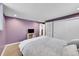 Bedroom with neutral color scheme, including a white comforter and lavender walls, creating a serene atmosphere at 12286 W Tennessee Ave, Lakewood, CO 80228