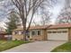 Charming single-story home with a well-maintained lawn, attached garage, and mature trees at 12286 W Tennessee Ave, Lakewood, CO 80228
