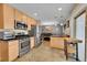Well-lit kitchen featuring stainless steel appliances, wood cabinets, and an attached dining area at 12286 W Tennessee Ave, Lakewood, CO 80228