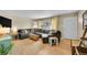 Bright living room featuring a large sectional sofa, hardwood floors, and a view of the neighborhood through the window at 12286 W Tennessee Ave, Lakewood, CO 80228