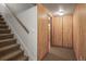 Carpeted stairs and hallway lead to wood-paneled bedroom with large closet at 245 S 13Th Ave, Brighton, CO 80601