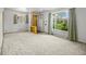 Bright living room with large windows, neutral carpeting, and a decorative shelving unit at 245 S 13Th Ave, Brighton, CO 80601