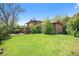 Exterior view of home showcasing a large backyard, mature landscaping, and natural shade trees at 12289 W Atlantic Ave, Lakewood, CO 80228