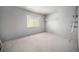 A bright, empty room features a neutral carpet, a window, and a closet at 12289 W Atlantic Ave, Lakewood, CO 80228