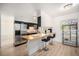 Well-lit kitchen with an island bar, stainless steel refrigerator, and modern finishes for cooking and entertaining at 12289 W Atlantic Ave, Lakewood, CO 80228