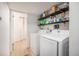 Functional laundry room with new appliances, open shelving, and an adjacent full bathroom at 12289 W Atlantic Ave, Lakewood, CO 80228