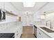 Open concept kitchen with white cabinets, modern appliances, and hardwood floors at 18302 E Kepner Pl # 207, Aurora, CO 80017