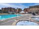 Outdoor pool and hot tubs with seating areas and views of surrounding buildings and blue sky at 680 S Main St # 18, Breckenridge, CO 80424