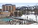 Outdoor pool surrounded by lounge chairs with a building and snow-covered mountains in the background at 680 S Main St # 18, Breckenridge, CO 80424