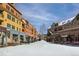 Charming street view of boutique-lined sidewalks, nestled between colorful buildings and dusted with snow at 680 S Main St # 18, Breckenridge, CO 80424
