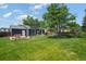 Spacious backyard with lush grass, patio furniture, and mature trees at 5170 Deephaven Ct, Denver, CO 80239