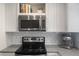 The kitchen features sleek stainless steel appliances and white cabinets, complemented by subway tile and a dark countertop at 5170 Deephaven Ct, Denver, CO 80239